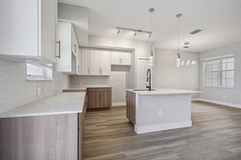 A white kitchen with a large island in the middle of it